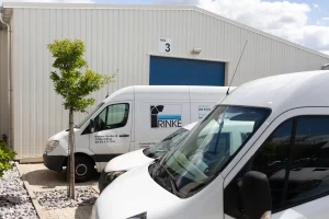 Drei RINKE-Fahrzeuge parken vor der Produktionshalle des Betriebs